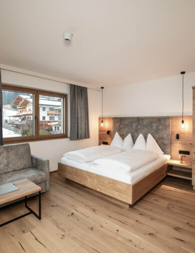 Moderne und großzügige Zimmer mit viel Holz und grauen Akzenten.