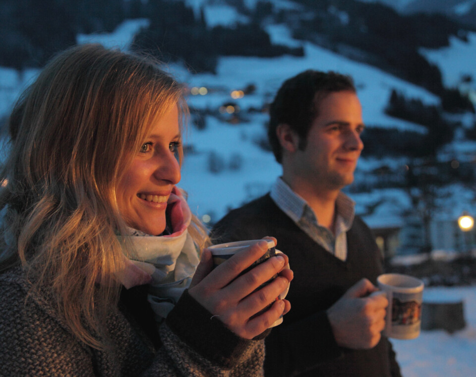 Ein Paar genießt einen warmen Glühwein, während sie der Adventmusik im Hintergrund zuhören.