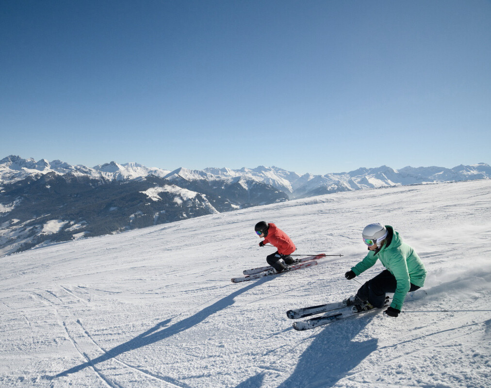 Zwei Skifahrer auf den breiten Pisten in Großarl - Sonnenskilauf im Urlaub im Hotel Diellehen.