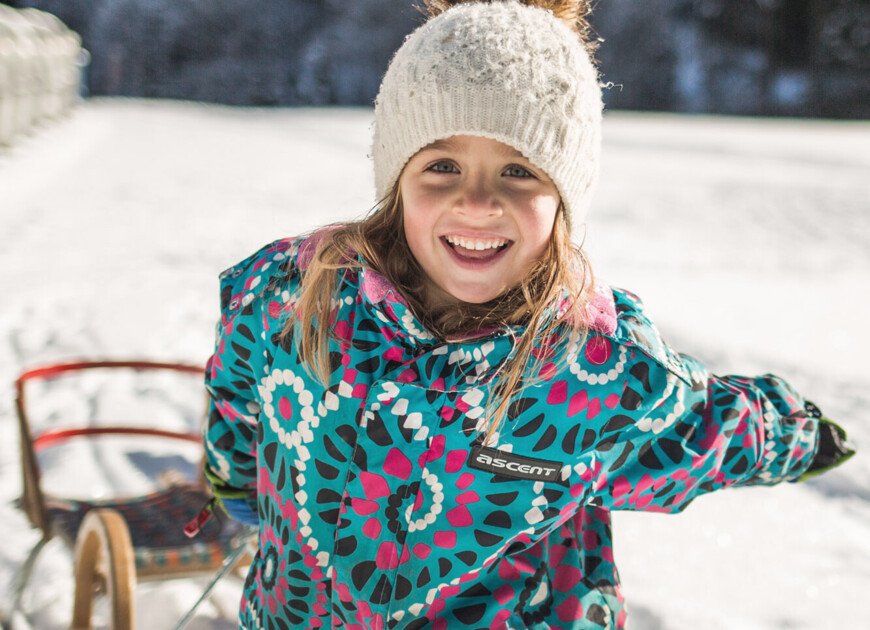 Kind mit Rodel im Familienurlaub im Winter im 3 Sterne Hotel Diellehen in Großarl.