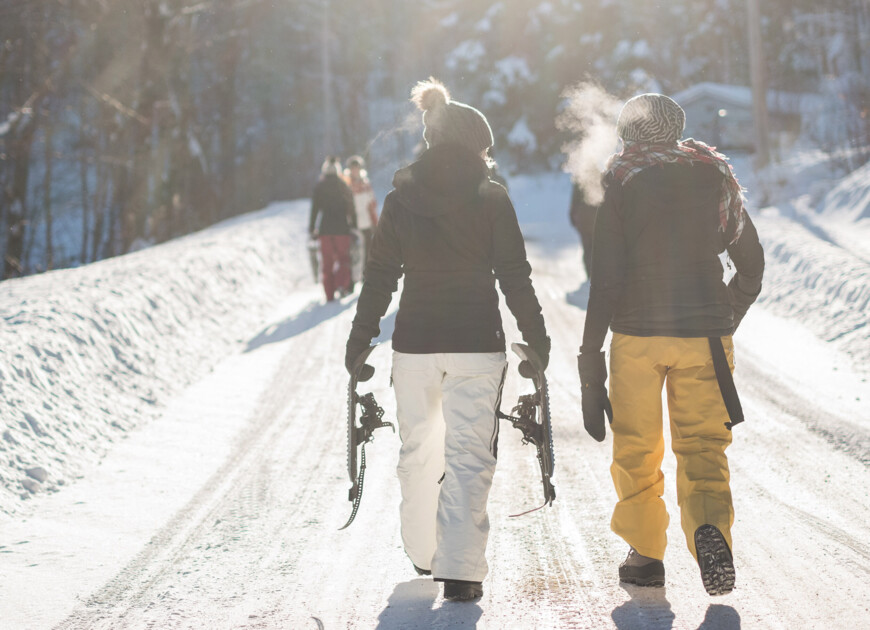 Paar mit Schneeschuhen auf einer Forststraße im Winterurlaub in Großarl.