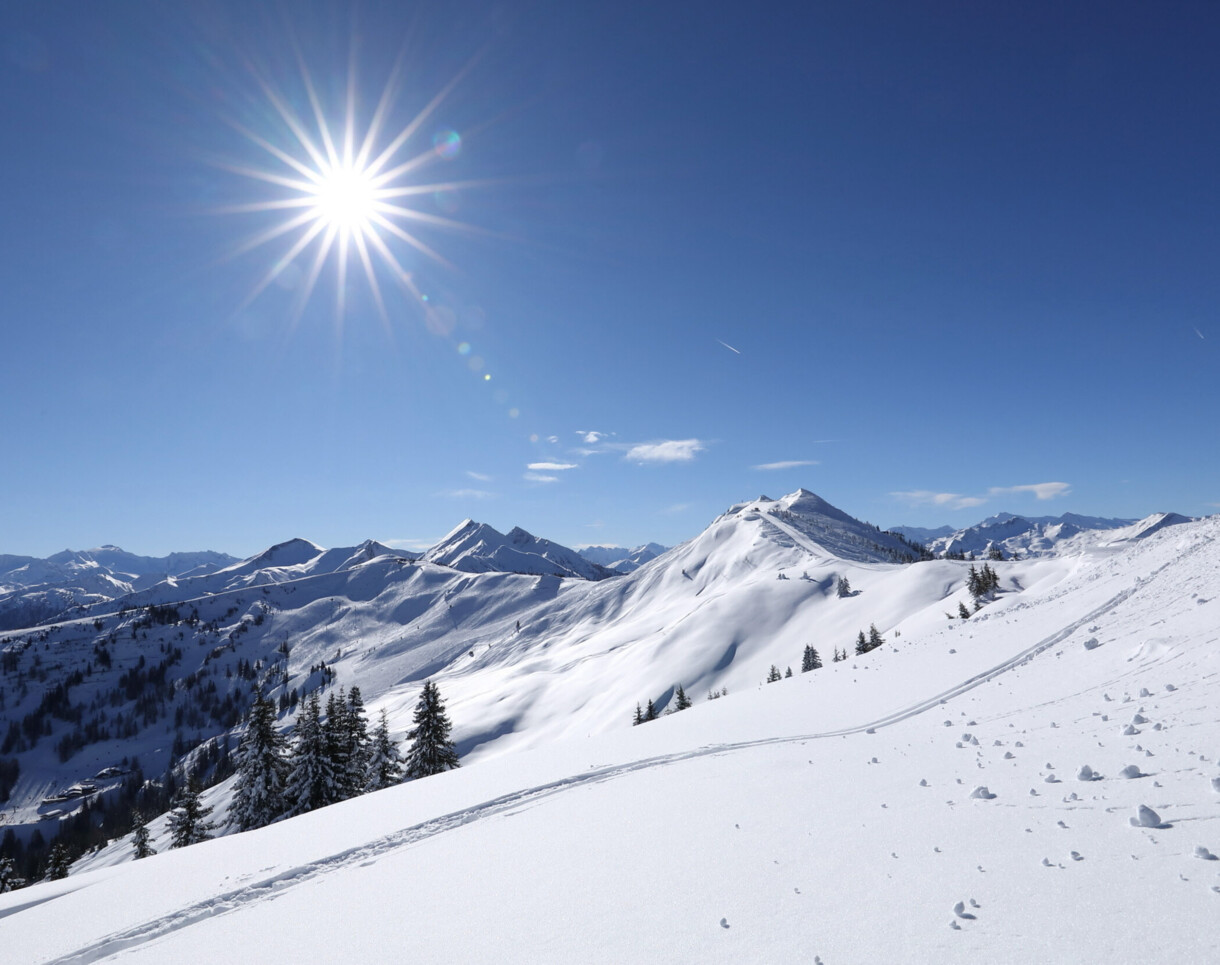Tief verschneite Berge und bestens präparierte Pisten im Skigebiet Großarl, Salzburger Land.