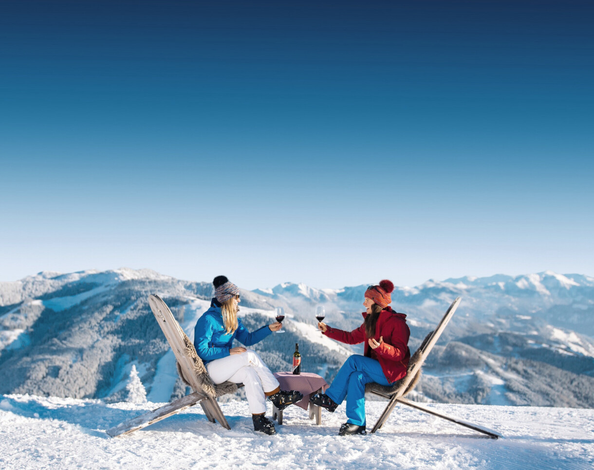 Zwei Skifahrerinnen mit Weingläsern im Skigebiet Großarl.