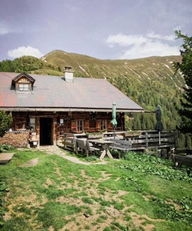 Strahlender Sonnenschein und blauer Himmel am Gipfel des Berges mit einem Gipfelkreuz.