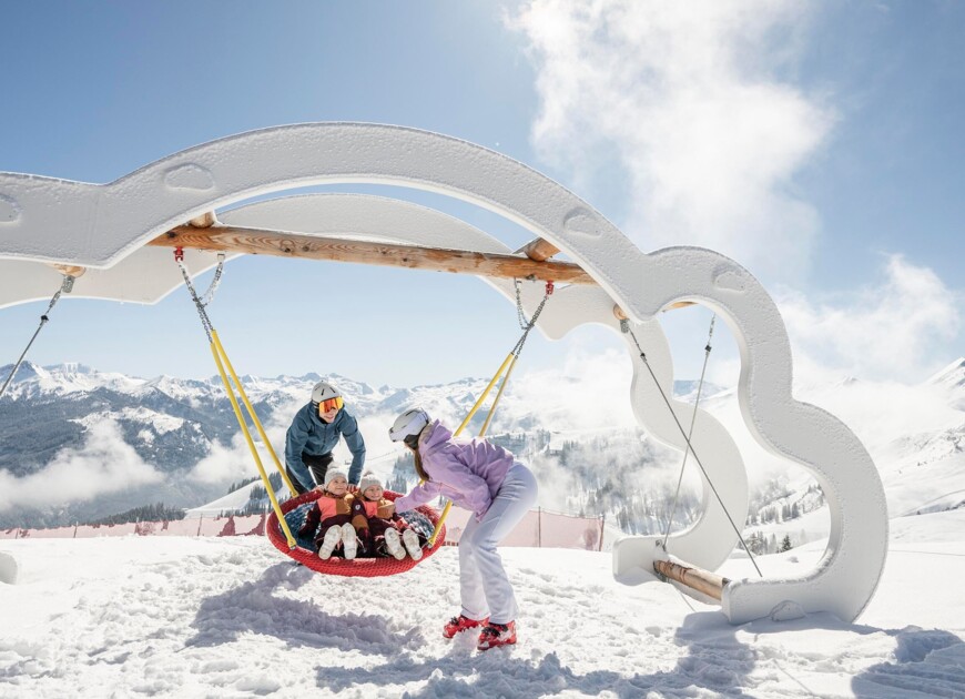 Eine Mutter mit Tochter auf den Skiern in der tief verschneiten Winterlandschaft im Skigebiet Großarl.