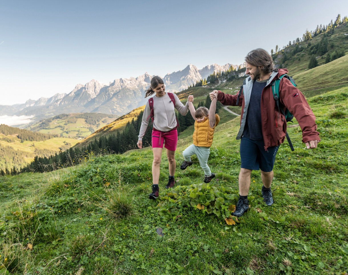 Familie mit Kind beim Wandern auf einer Alm in Großarl, Salzburger Land.