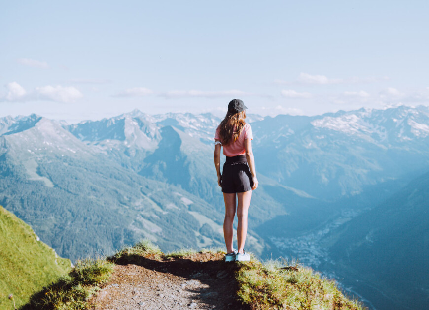 Junge Dame am Berggipfel mit Panoramablick über das Großarltal im Salzburger Land.