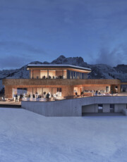 Bergstation der Kieserlbahn mit Panoramablick bei Dämmerung. Personen genießen die Aussicht auf der Terrasse.