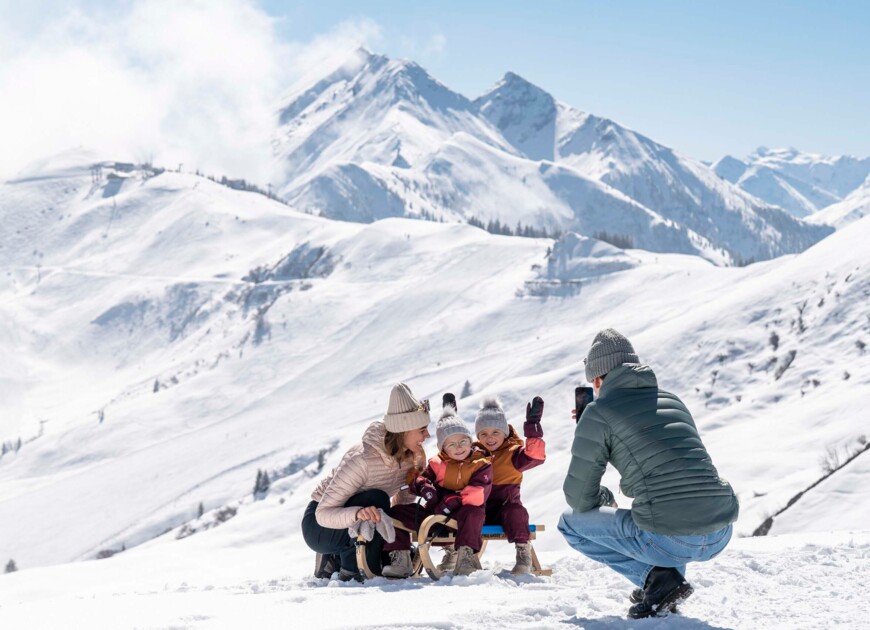 Familie mit Rodel im Familienurlaub im Winter im 3 Sterne Hotel Diellehen in Großarl.